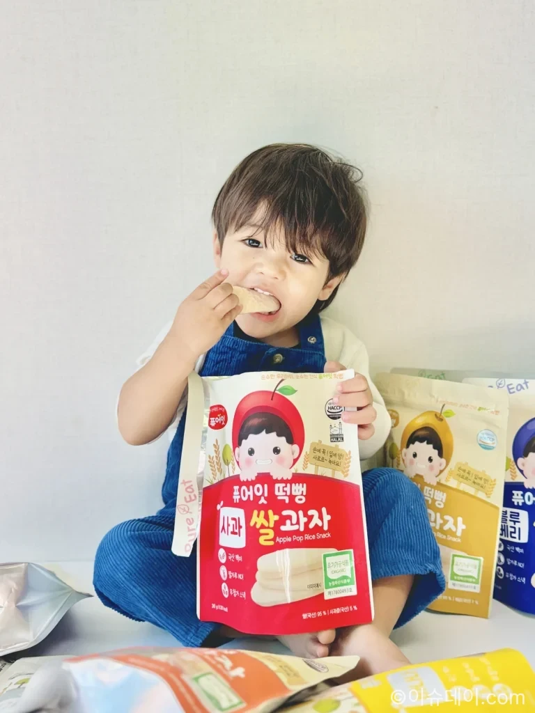 퓨어잇 유기농 떡뻥 사과맛 제품을 아기가 손에 들고 있는 모습