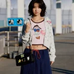 i-dle 소연이 2026년 6월 26일 홍콩 월드투어 출국길에서 코치 브레인 데드 협업 컬렉션을 활용한 빈티지 공항패션을 선보였다. 핑크 탱크톱, 플라워 후드 집업, 소프트 태비백 스타일링을 정리했다.