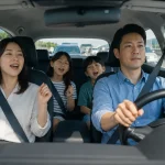 휴가철 교통체증 속에서 안전하게 노래를 따라 부르는 가족