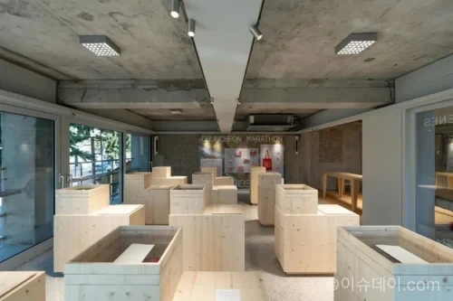 프로-스펙스 서촌 플래그십 스토어의 노출 콘크리트와 흰 철제 프레임 내부